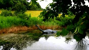 Loch Ness monster in the small lake at typical summer cloudy evening. Scotland