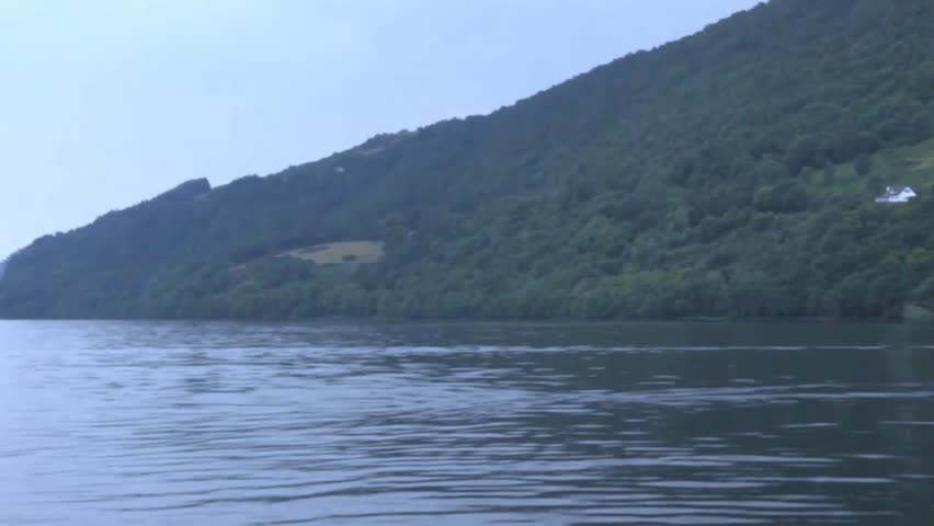 Loch Ness, the most famous lake in Scotland at typical summer cloudy evening. Shooting from the ship rocking on the waves