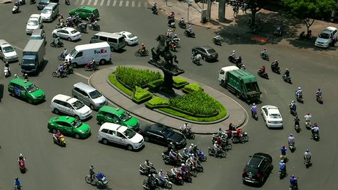 Ho Chi Minh City - April 2015: Roundabout aerial view with traffic. Zoom out time lapse.