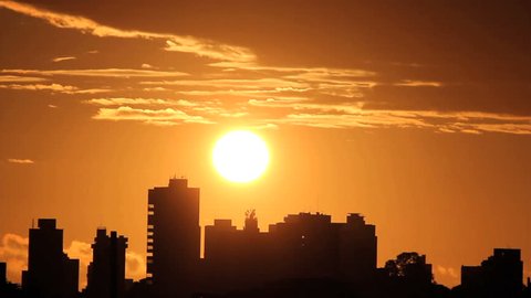 Sunrise, brazilian skyline. Silhouette buildings and golden sun. Time lapse. 
