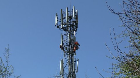 WORCESTER,UK - APRIL 14 2015 : Maintenance workers carry out repairs high up on a communications tower using safety equipment
