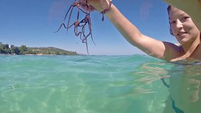 Teen hold up starfish and let it live underwater, slow motion stock video