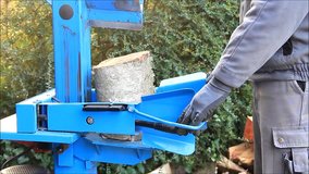 worker with wood splitter in action, hydraulic, electric, firewood 
