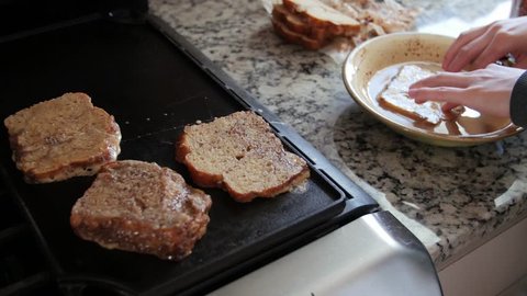 A woman makes delicious french toast for breakfast in the morning