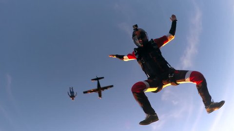 Skydiving people in free fall at sunset, point of view camera. Adventure freedom concept.