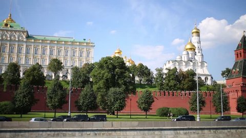 Traffic on road near of Kremlin walls and Grand Kremlin Palace in Moscow at summer day. View from river