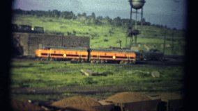 (1950s 8mm Vintage) Trainyard Iron Ore. A gritty look at an industrial train yard stacked with yellow iron ore.