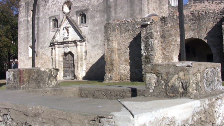 Video pan up from well to cross old Spanish Mission Concepcion San Antonio, Texas. Built early 1700â€™s by missionaries from Spain and local Indians. Bell tower cathedral, rock well and stone walls. 