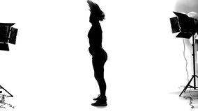 Black silhouette of professionally dancing twerk girl in studio on white background