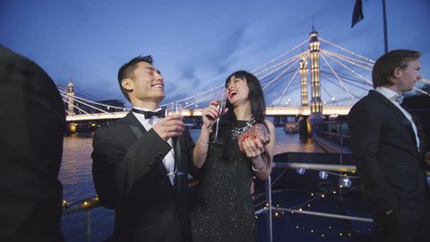 4K Attractive Asian couple chatting on boat deck during party at night