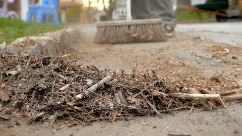Cleaning yard debris, sweeping broom in slow motion 