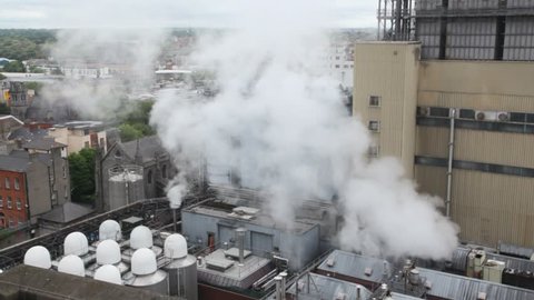 water vapor rising up to cityscape from factory