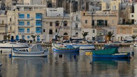 The view on traditional Maltese boats in sunset, Kalkara, Malta