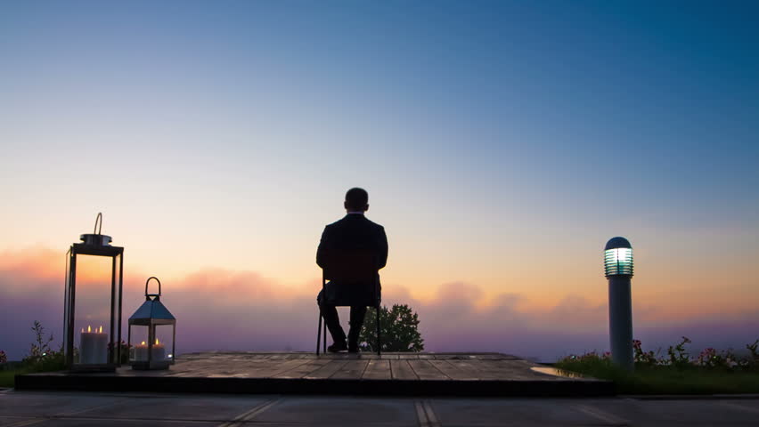 businessman in the morning on the terrace admiring the sunrise