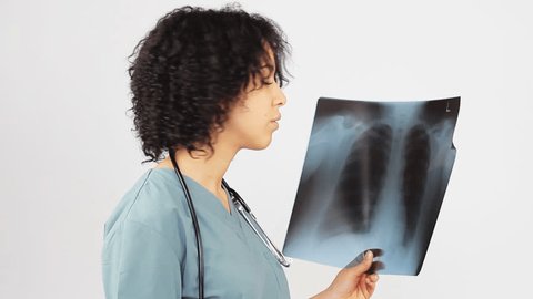 Female Nurse Looking At A Chest X-ray Wearing Hospital Scrubs