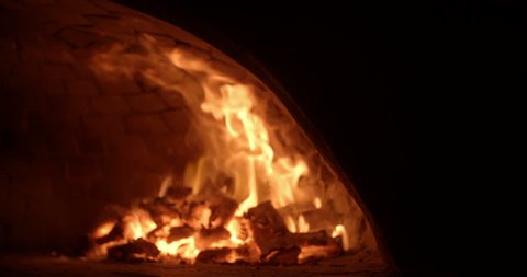 traditional wood fire pizza oven with flames in slow motion