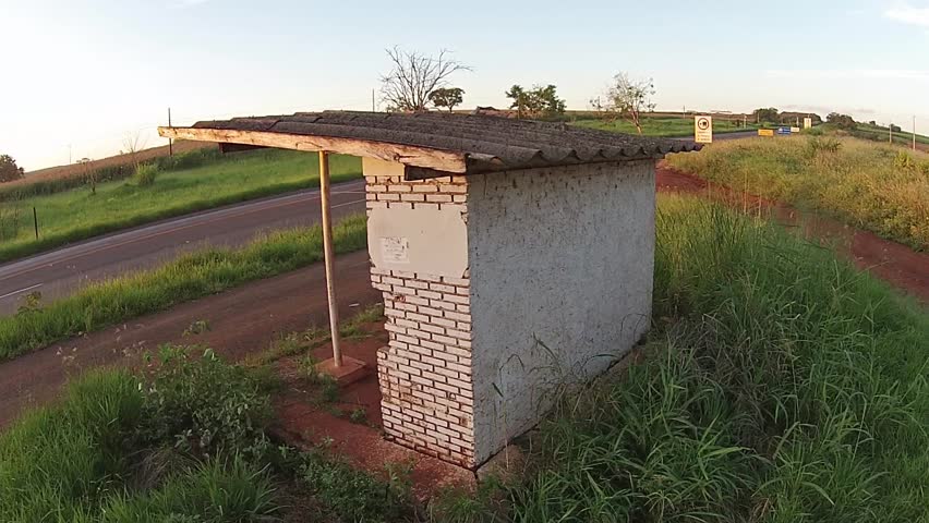 Aerial view up revealing road with car passing to and corn plantation in the background