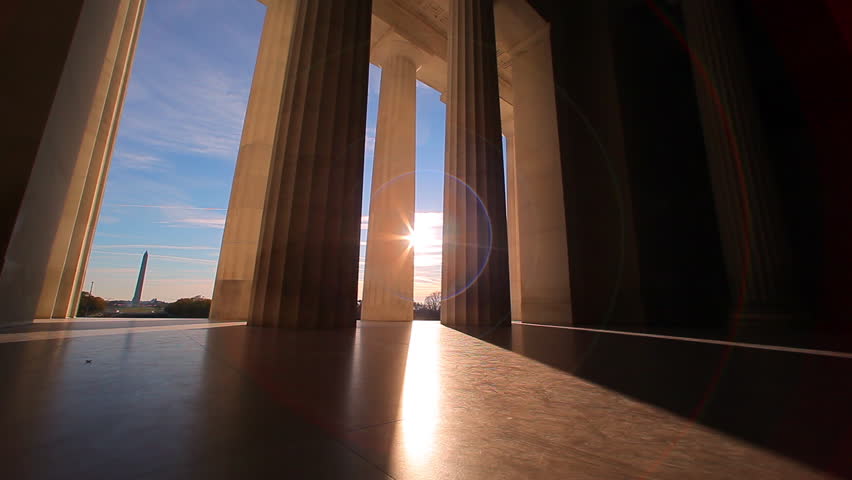 Lincoln Memorial in Washington, DC,United States Government -  tracking shot with sun lens flare  between the bottom of the pillars. 