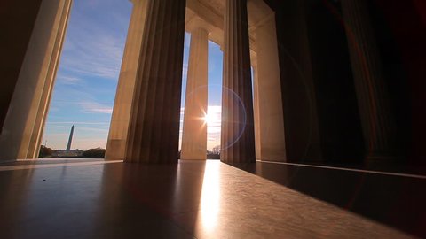 Lincoln Memorial in Washington, DC,United States Government -  tracking shot with sun lens flare  between the bottom of the pillars. 