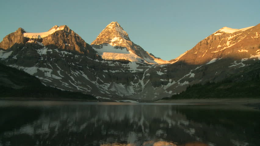 Tilt down to reflection of Mount Assiniboine in the Canadian Rockies