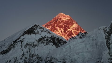Mount Everest golden sunset time-lapse. The sunlight on the peak and west face turns red and then fades to black.