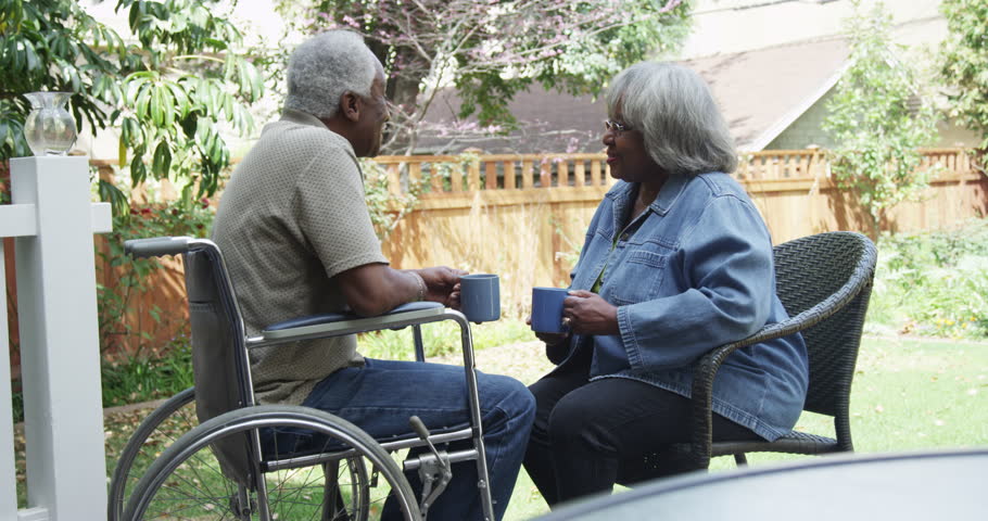 Sweet African couple sitting on porch drinking coffee