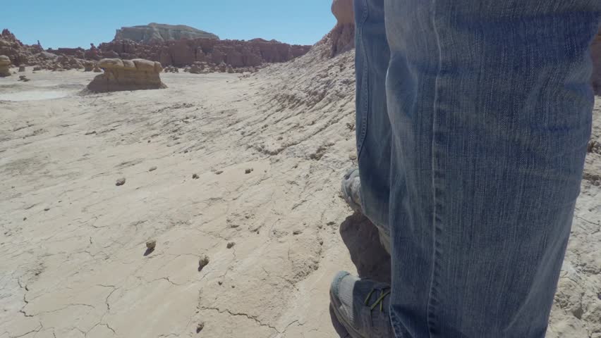 Families walking through goblin valley state park in the hot desert of southern Utah.  Shot using a gimbal for stabilization