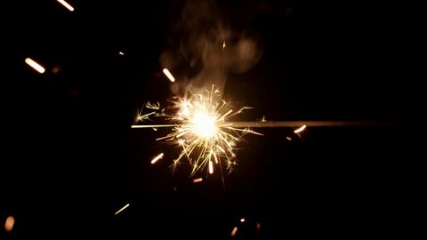 Sparkler burning from left to right in center of black background.  Recorded in 4K at 60fps.