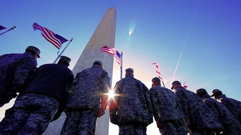 US military soldiers saluting the American Flag at the Washington Monument while showing respect and patritism, Washington DC, November 2012