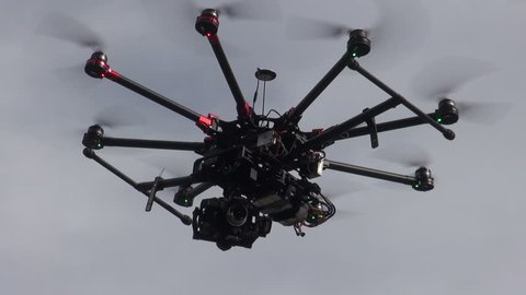Professional drone flying in the air, in a aerial shot.
