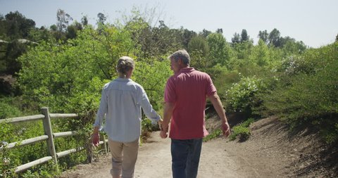 Senior married couple walking on trail together