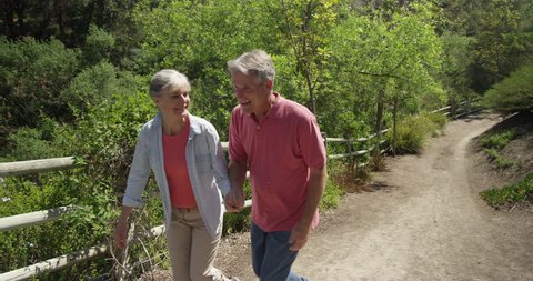 Happy mature couple walking on trail