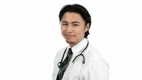 An attractive doctor wearing a white shirt with a stethoscope around his neck feeling great. Video on white background.