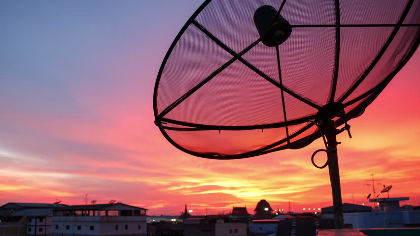 Time lapse shot of satellite dish on evening background.
