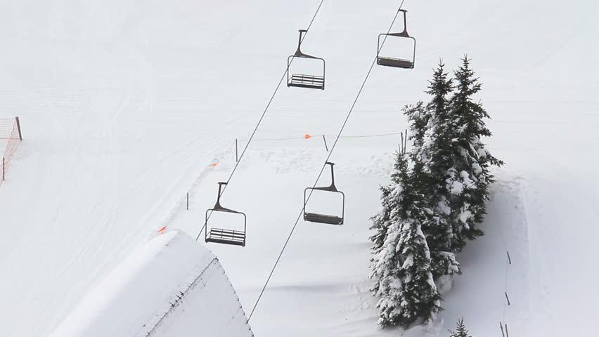 Skiers ride a ski lift to the top of the mountain.
