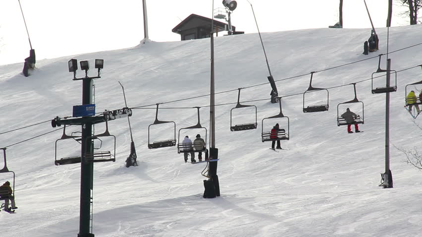 Skiers ride a ski lift to the top of the mountain.