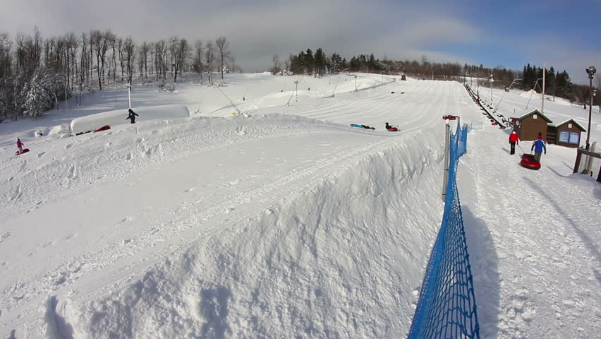 Riders slide down a snow tubing hill.