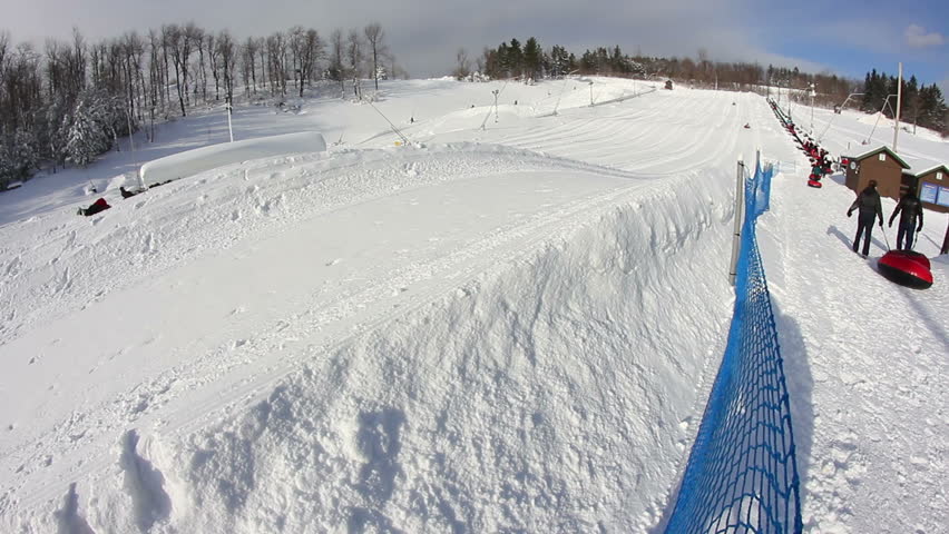 Riders slide down a snow tubing hill.