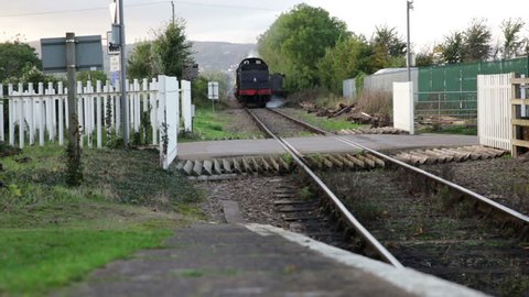 WATCHET STATION, UK, CIRCA OCTOBER 2014 - West Somerset Railway heritage line, train arrives with unidentified senior man driving train and young girl with head out of window, October 2014