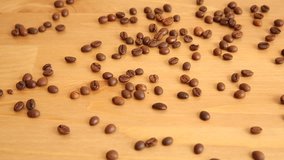 A sliding view of coffee beans on a table with sharp focus.