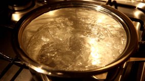 A close view of water boiling in a stainsess steel pot.