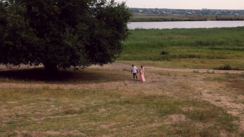 beautiful young couple, the woman - pregnant, walking on a beautiful landscape