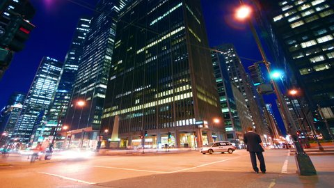 Timelapse of driving and cars racing by with streaking lights on Wacker Drive at night in Chicago with deep blue sky with super long exposures for each frame.