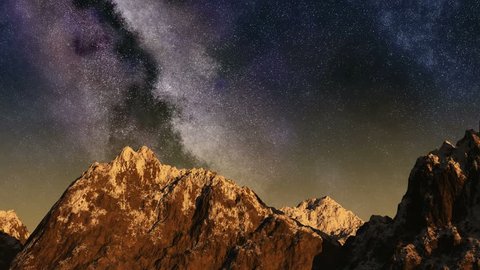 Time lapse of the sunrise from night sky with stars passing by behind mountain