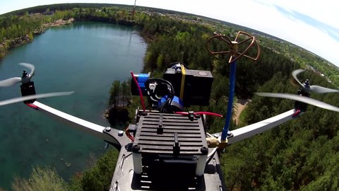 Flying drone with camera filming lake. POV clip