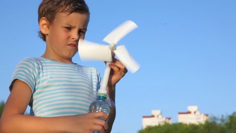 boy holding toy wind-driven generator in his hands