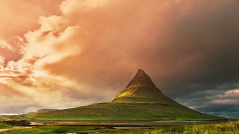 Iceland - 15 June 2015: Kirkjufell - mountain in the western part of Iceland, located near Grundarfjordur. Sunset with running clouds and grass moving in the breeze. 4K TimeLapse
