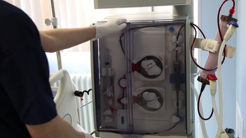 Nurse Works with Dialysis with Medical Device
