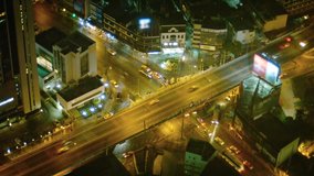 FullHD video - Light traffic on a freeway overpass above a major intersection in downtown Bangkok. Thailand. at night with well-lit towers and commercial buildings.