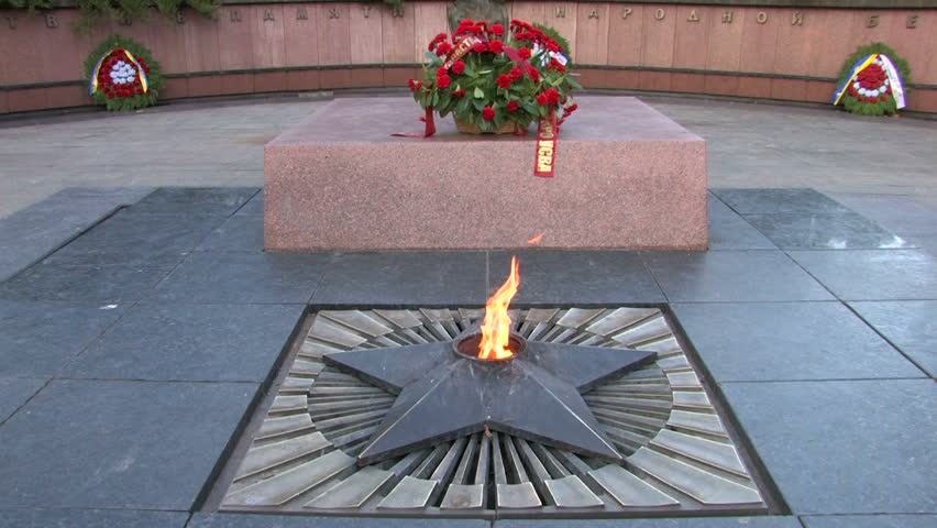 Eternal flame with wreath of flowers at the monument  